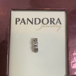 Pandora berlock nyskick retired  - Berlock i sterling silver,aldrig använt. Legat i original förpackning tillsammans med andra berlocker sen 2005/06. Ingen egen ask. Tillverkas ej mer. Märkt 925/ALE (pandoras stämpel) Heter: Retired Sterling Silver Small Roses Spacer - 790176