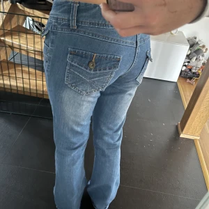 Lågmidjade jeans - Supersnygga jeans med fina detaljer men är tyvärr lite för stora för mig💕 fint skick, kom priv för fler bilder elr feågor🤩 mått, inerbenslängd: 72 cm midja: 37 cm rakt över (är dock streshiga), se bild 3 för hur höga i midjan de är.