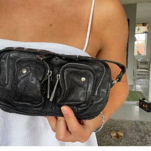 Nunoo väska - Liten svart Nunoo väska i modellen Helena. Köpt för ca 1200kr. Superbra skick, har bara inte kommit så mycket till användning. Frakt tillkommer:) 🥰
