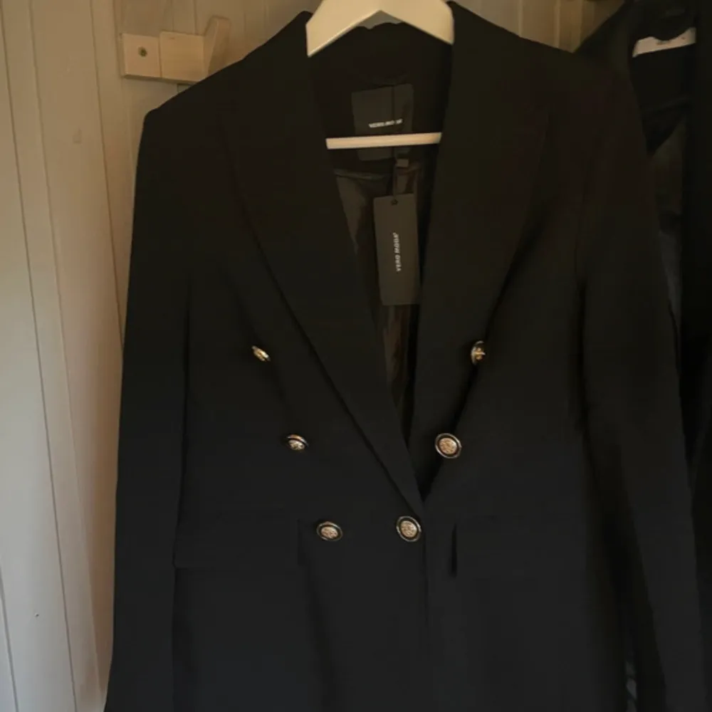 Kavaj / blazer med superfina guldknappar, helt ny och har aldrig använts då jag tycker den är lite för stor på mig! Rak i modellen. Kostymer.