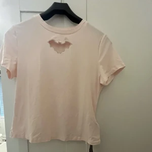 Rosa t-tröja utklippt Batman logga - Ny med tagg köpt från Shein / Romwe. storlek passar den 42/44 i mitt tycke (är en 44a)  Batman logga utklippt mot bröst-klyftan så att säga 😅