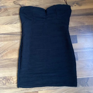 Mini tubklänning   - En super fin tub-miniklänning i svart. Materialet är extremt fint, tjockt och stretchigt (där av förlåtande). Klänningen framhäver kroppsformen väldigt fint. Svagt vadderad vid bysten. Aldrig använd, säljer då den inte passar. 