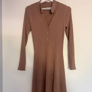 Långklänning - Brun ribbad stretchig långklänning från neo noir. Storlek 34 (kan även passa 36/38) Använde 1 gång  Rek pris 1099kr