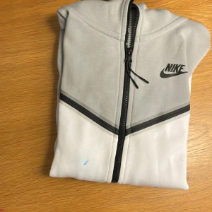 Nike Tech Vit/Grå - Min gamla Nike Tech.  Små blå fläckar på den (går inte bort) därför så billigt pris. Storlek XS Originalpris: 1300kr
