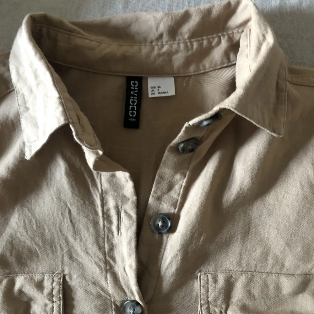 Beige blus/ skjorta från H&M i storlek S/36, nyskick . Blusar.