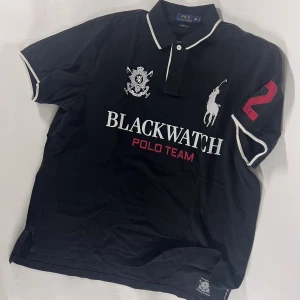 Ralph Lauren piké från 2003 - Designed to celebrate the BlackWatch Ralph Lauren Polo Team, this polo shirt is made from soft cotton mesh and features our signature embroidered Big Pony. XXL
