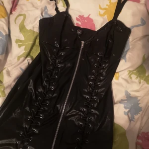 Addiction dress - Otroligt fin klänning i fejk skinn, kort och med snörning från brösten och ner. Storlek M men väldigt mycket stretch