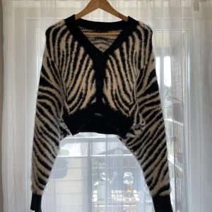 Zebramönstrad kofta - Kroppad, zebramönstrad kofta i kortare modell med stora armar.