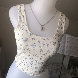 ୨Blommig Topp୧ - Söt ”créme vit” topp med små blå blommor på & ett slags randigt mönster i tyget. Endast använd ett fåtal gånger för länge sedan. Tunnt & lent material & perfekt till i sommar. Fri frakt ända tills 24 juni. Läs gärna Bio<3