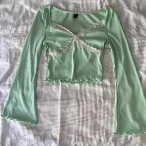 Grön topp med spets detaljer - Säljer dennna mint gröna topp med vida ärmar och spets från shein! Den är nästan som ny endast använd några gånger! Skriv vid ärligt intresse