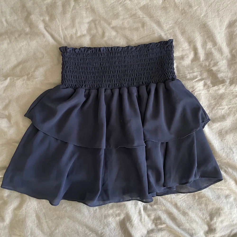 Säljer denna supersöta marinblåa kjol från Chelsea! Den är använd max 3 gånger och är i nyskick. Super söt till sommaren men även nu till hösten ihop med ett par tunna strupbyxor och en stickad tröja!. Kjolar.