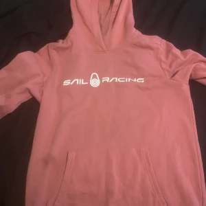 Sail Racing hoodie  - Mörk Rosa Sail Racing hoodie i bra skicka och har knappt använts.Sitter ganska bra för mig som brukar ha medium/170,köpte den för 900
