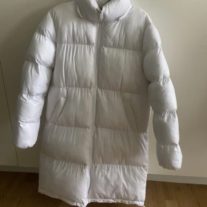 Vit långjacka  - En vita långjacka från plt i storlek 34! Jackan har en avtagbar luva!
