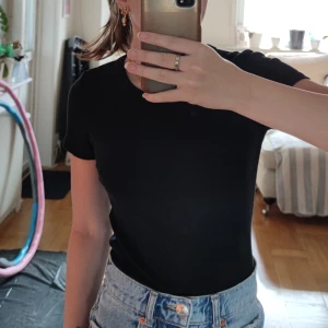 Svart tröja - Svart ribbad t-shirt från h&m. Den är lite tajt i modellen. 