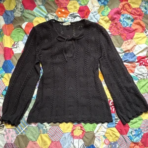 Super snygg stickad tröja  - Fin och speciellt stickad tröja, gjort i England! Fin snörning vid halsen, snörning vid ärmarna så att dom antingen är utsvängda eller lite bell sleeve :) Smal i midjan som hänger ut vid höfterna 