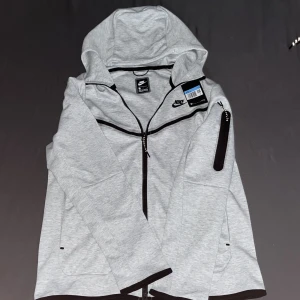 Nike tech grå - Säljer Nike tech den va för liten och hittar ej kvitto på den skriv via intresse!