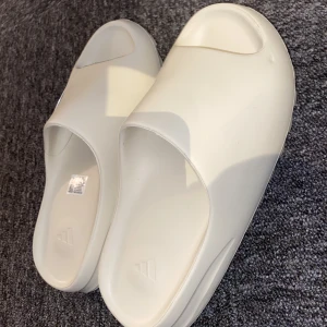 Yeezy Slides - Säljer mina yeezy slides eftersom dom är för små för mig, storlek 39-40. Okej kvalite och skick. Tofflorna är inte authentiska men bra kvalite (betalning sker vid swish endast)