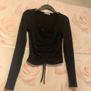 Långärmad  - Svart långärmad tröja man kan dra åt snöret och den blir tajtare och mer urringad. 