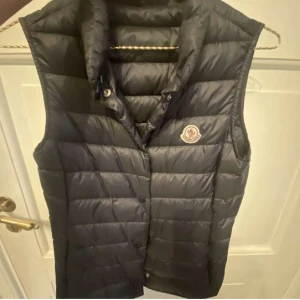 Moncler väst - Marinblå moncler väst köpt på NK i storlek 14y(164), motsvarar xs/s. Västen är köpt för ca 3400kr, har även fickor på sidorna 😊 Pris kan diskuteras 