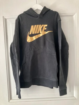 Svart hoodie nike - Snygg nike hoodie, svart med guldlogga. Storlek 152.