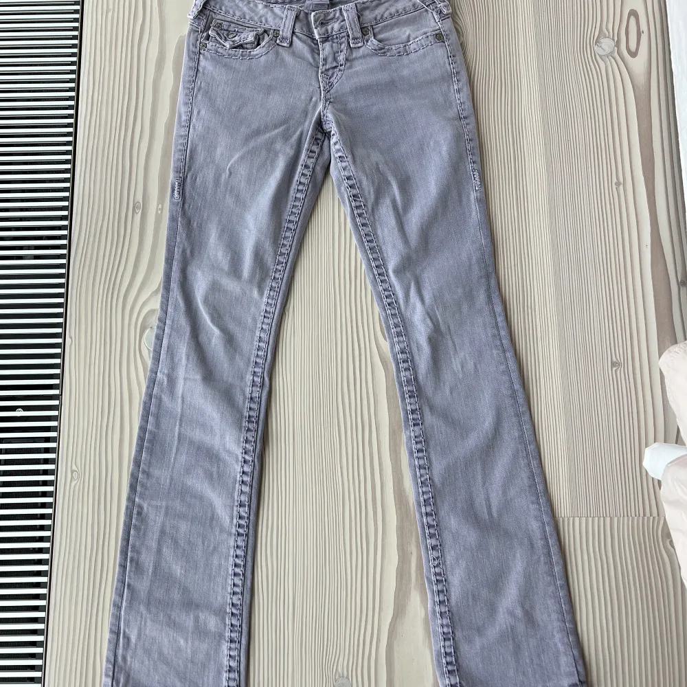 Super coola och unika true religion jeans! Dem är bootcut och lågmidjade. Färgen är ljus/pastell lila. Väldigt bra skick! Som nya.  Storleken kan jämföras med en 36-38. Jag är ca 160 lång. Innerbenslängd: 82cm. Midjemått: 36 cm rakt över, alltså diametern. Jeans & Byxor.