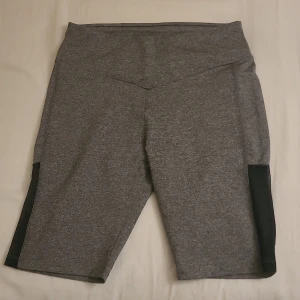Cykelbyxor  - Gråa cykelbyxor med meshdetalj på sidorna. Har aldrig använts. 