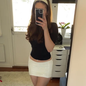 Vit minikjol med detaljer - Säljer min skitsnygga minikjol från hollister. ❤️ Den har broderier (?) i form av blommor med paljetter som ramar om dem. Smått använt men i bra skick förutom en pytteliten fläck men den går bort i tvättmaskninen. Köpare står för frakt! 🫶