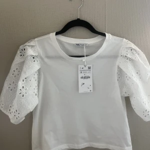 T-shirt / topp  - En fin vit t-shirt med puffärmar med spets. Helt oanvänd i mycket bra skick. Priset kan diskuteras, skriv för fler bilder!🫶🏼🫶🏼