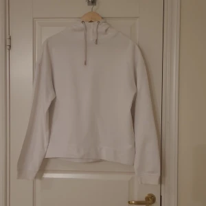 Vit huvtröja  - Vit huvtröja med hög hals. Använd ett fåtal gånger. 