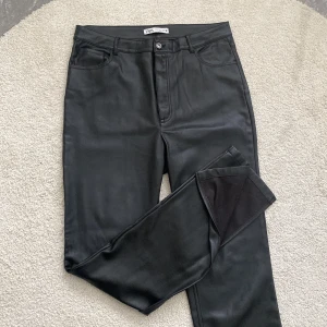 Byxor i PU-läder med slits - Supersnygga byxor i PU-läder från Zara. Slits nedtill på båda benen! Byxorna är o gott skick och säljer då de ej kommer till användning längre!🌼