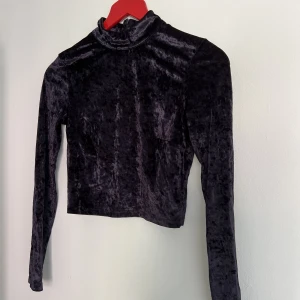 Cropped sammetspolo - Svart polo i sammet. Croppad. Dragkedja bak. Strl 38