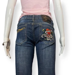 Lågmidjade Ed Hardys - Ed Hardy lågmidjade jeans i fint skick! Kristaller på baksidan saknas. Storlek 27. 98% bomull och 2% elastan.  Höftbredd 36cm Innerbenslängd 80cm 