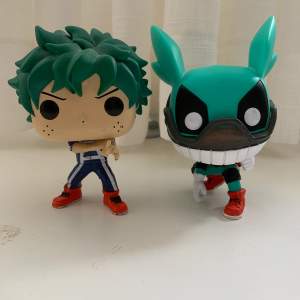 2 funko pop figurer på midoriya izuku, både har någon sorts skada tyvärr.  den högra har skador på ansiktet, håret och på fingrarna medans den vänstra har missfärgning på baksidan av hjälmen