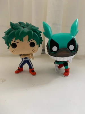 2 midoriya funko pop figurer - 2 funko pop figurer på midoriya izuku, både har någon sorts skada tyvärr.  den högra har skador på ansiktet, håret och på fingrarna medans den vänstra har missfärgning på baksidan av hjälmen