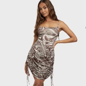 Draperad klänning från Nelly - Brun draperad klänning från Nelly i storlek S, aldrig använd.   Köparen står för frakten✨