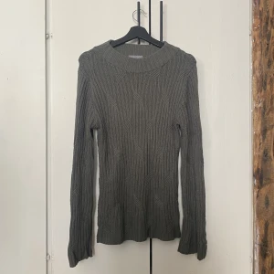 Grön stickad tröja - Den ser grå ut på bilden men är en blandning av sage och oliv! Jätteskön och väldigt lång. Den är även väldigt stretchig och har ett snyggt märke på ärmen.   Säljer den för att den är för stor för mig.