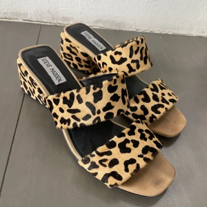 Steve Madden Sandaletter med klack - Snygga & unika Steve Madden sandaletter med klack. Använda ett fåtal gånger, i bra skick. Klackhöjd 6,5cm, storlek 41. Passformen är normal, men lite åt det bredare hållet.  Materialet är grovt ”pälslikt”.