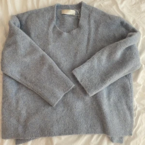 Carin Wester sweater  - En jätte fin CARIN WESTER tröja som aldrig använts. Den var för stor i storleken. Nypris 2000 kr. Den är fin ljusblå färg, kameran fångar ej upp den riktiga färgen riktigt, sista bilden visar färgen mer 🩵