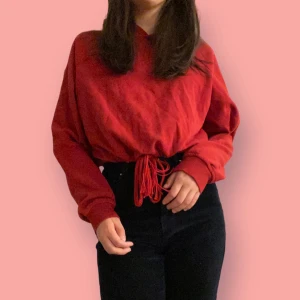Röd huvtröja/mini hoodie - Köpt hos H&Ms collection ”DIVIDED” och är i jätte bra skick! Finns ett snöre i framsidan som gör att man kan justera till föredragna passform plus en fin detalj! (60% Cotton, 40% Polyester)