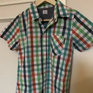 En rutig, multifärgad barnskjorta från Polarn och pyret. Har aldrig använts. 