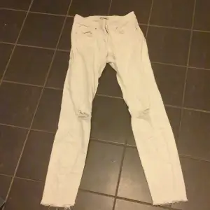 Vita jeans med hål för knäna