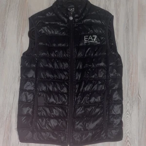 Ea7 väst äkta - En väst som är i väldigt bra skick.  Finns ett fel på den och de är att den har haft ett pytte litet hål som jag har tejpat för som knappast syns på långt håll.   Storlek L/ Äkta så klart Ny pris: 1200