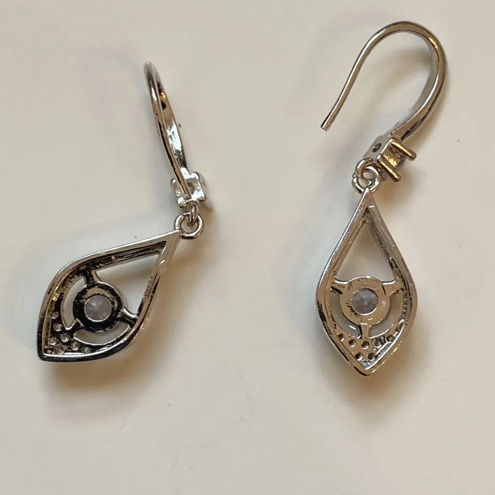 Små silverfärgade örhängen med rhinestones  Okänt material . Accessoarer.