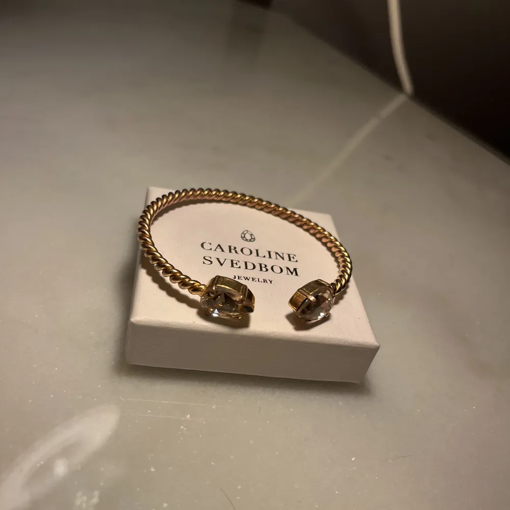 Mini drop bracelet i guldfärg från Caroline Svedbom. Nypris 695kr.. Accessoarer.