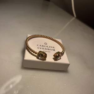 Mini drop bracelet i guldfärg från Caroline Svedbom. Nypris 695kr.