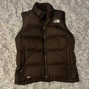 The North Face Väst - Brun, varm och perfekt till hösten, i storlek M men passar mig perfekt som har S. Äkta The North Face väst som aldrig kommit till användning. Budgivning som gäller! Skriv om nu undrar något eller vill ha fler bilder💗