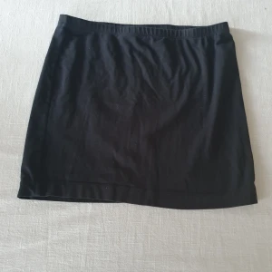 Bomullskjol i stretch - En kort svart basic bomullskjol i stretch. Använd men i fint skick.