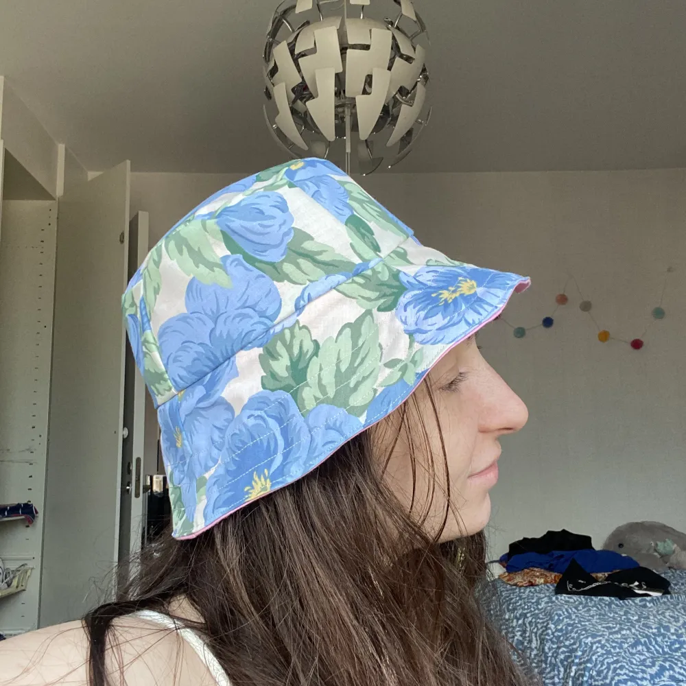 Handgjord buckethat av återvunnet/ upcyclat tyg. Den är reversibel! Ljus rosa eller blå blommor. . Accessoarer.