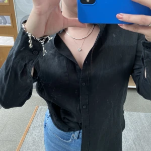 Svart linneskjorta - Likadan skjorta som tidigare annons fast svart. Bra skick. Från H&M, färgen ser kanske lite konstig ut på bild men den är en vanlig svart linneskjorta. Önskas fler bilder är det bara att skriva!