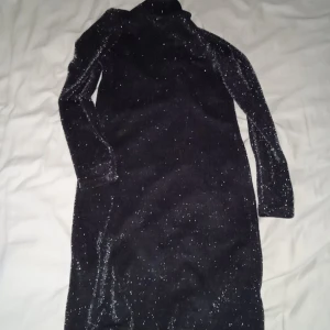 Svart glittrig klänning 👗 - Den är medel lång och svart med glitter.